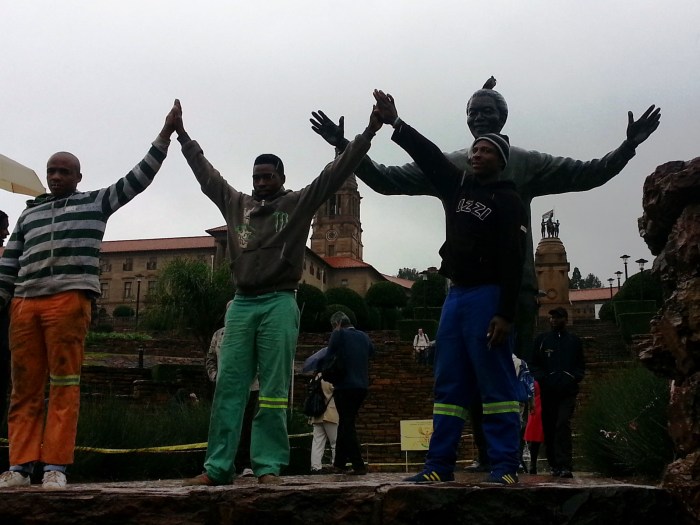 Nelson Mandela's legacy is everywhere. You can see his statue behind these young men who were posing for a photo.